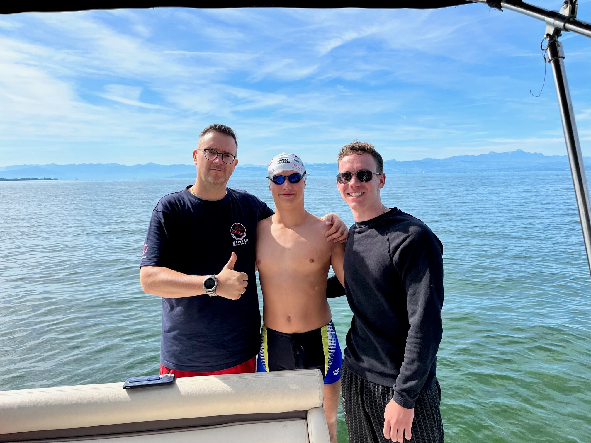 Moritz Nachbauer (Mitte) wurde im Ziel in Romanshorn von Veranstalter Oliver Halder (links) und Trainer Paul Hinderer empfangen. Bild: Halder