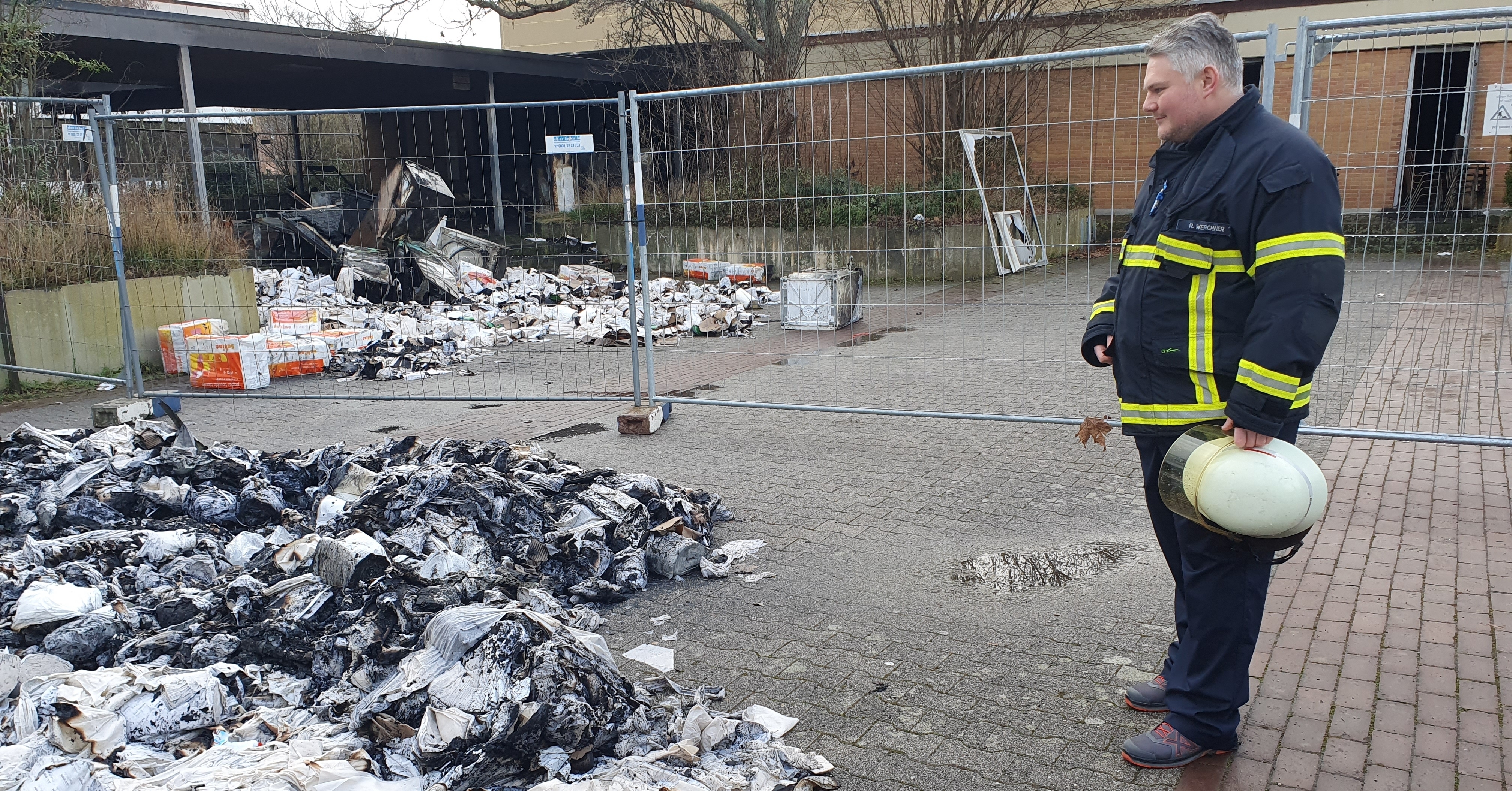 Feuerwehrmann Ralf Werchner vor den Papier-Rollen und Haushalts-Geräten, die die Feuerwehrleute aus dem Lagerraum ins Freie wuchteten und dort löschten.    Bild: Wegner