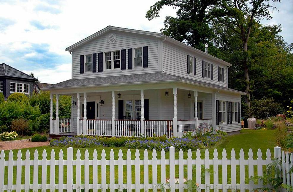 Überdachte Veranda, hellgestrichene Holzverschalung, Sprossenfenster – so kennt man amerikanische Häuser aus Filmen und TV-Serien.