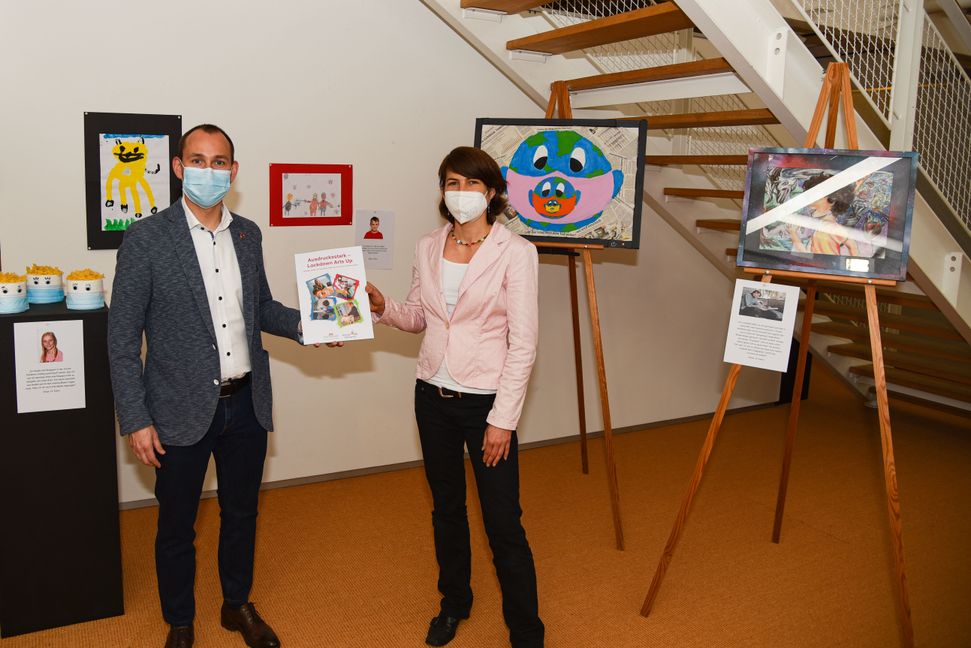 OB Dr. Stefan Belz und Janina Ulmer, Leiter des Böblinger Bildungsnetzes, mit dem Jugend-Kunstbuch vor den Gewinner-Kunstwerken in der Städtischen Galerie. Bild: z