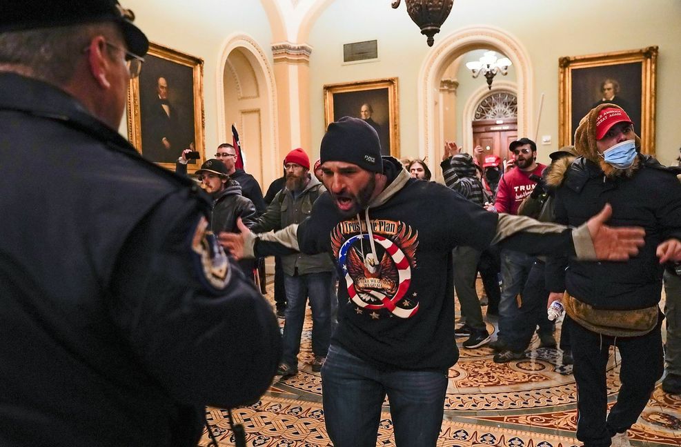 Demonstranten gestikulieren vor der US-Kapitol-Polizei auf dem Gang vor der Senatskammer im Kapitol in Washington, in das sie gewaltsam vordrangen.