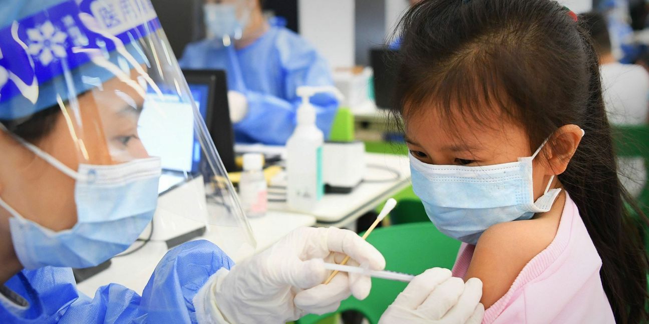 Ein medizinischer Mitarbeiter in China  injiziert einer Schülerin in einer Grundschule eine Dosis eines Corona-Impfstoffs. In Deutschland wird die Impfung ab Ende Dezember erwartet.
 Foto: dpa/Deng Hua