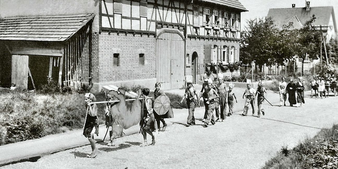 Blick in die Geschichte: Eine Gruppe in der Bahnhofstraße (heute Laurentiusstraße) beim Kinderfest-Umzug in den 50er Jahren. Bild: Archiv Arnau