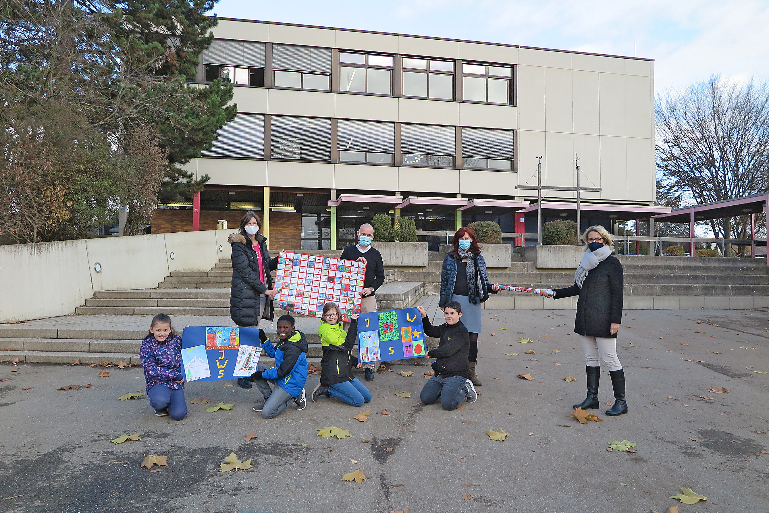 Heike Wörn (rechts, Bürgerstiftung Sindelfingen) übergibt das fertige Geschenkpapier an Lehrerin Stephanie Mornhinweg-Hadeler, Schulleiter Stefan Fahrner, Konrektorin Sabine Lalla (von links) und die Schüler Marlen, Bubacarr, Hanna und Sebastian von der Johannes-Widmann-Schule in Maichingen. Bild: Groß
