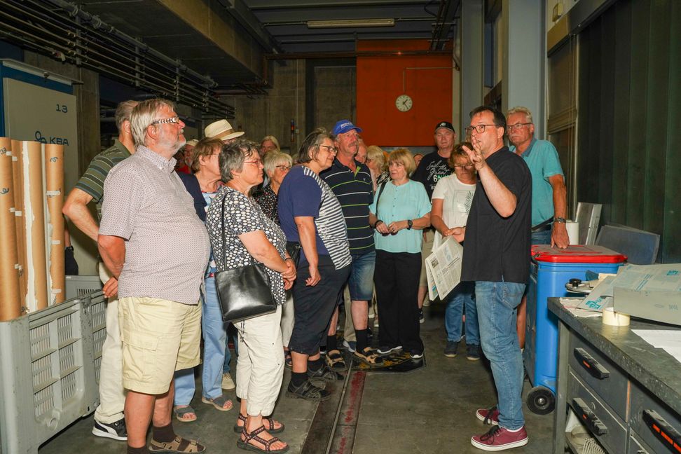 SZ/BZ-Redaktionsleiter Tim Schweiker führt eine Besuchergruppe durch die Druckerei.