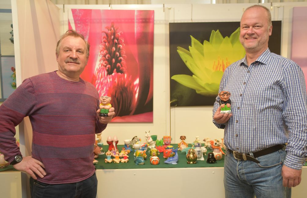 Erwin Steegmüller (links), Vorsitzender des Magstadter Heimatgeschichtsvereins, und Sammler Jochen Müller präsentieren zwei menschliche Eierbecher aus Müllers Sammlung. Im Hintergrund zwei von Müller am Computer bearbeitete Pflanzenfotos. Bild: Reichert