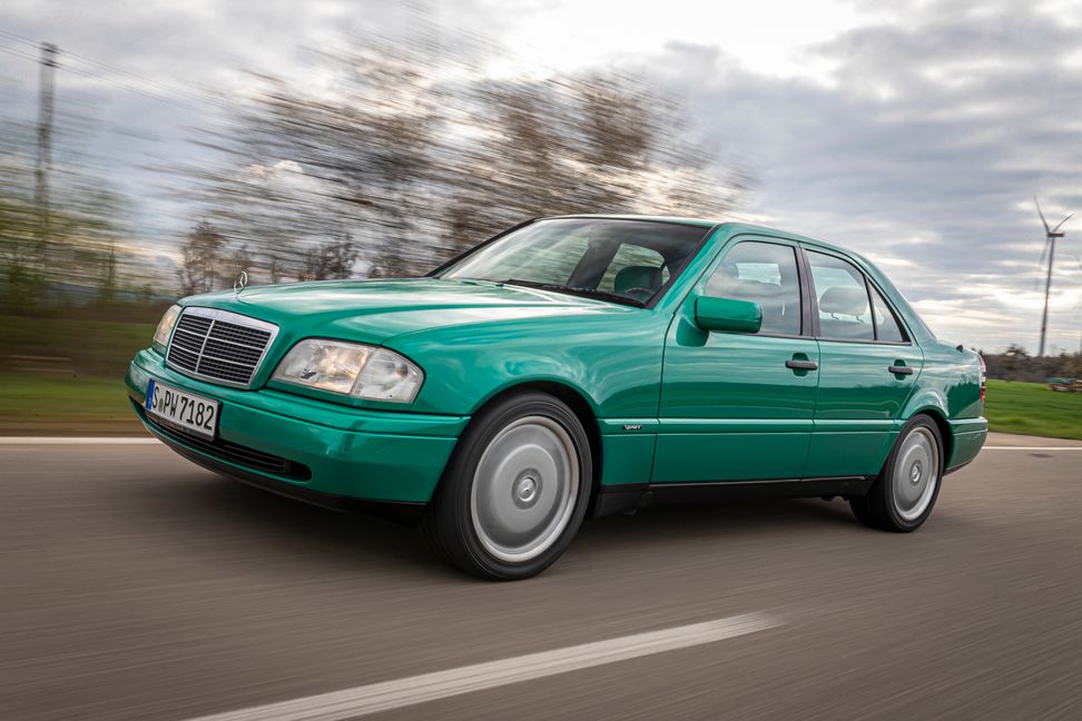 Mercedes-Benz C 280 (W 202), Baujahr 1996. Fahrzeug in der Ausstattungsline Sport mit Lackierung in designo grün metallic und Ton in Ton passendem Interieur. Fahraufnahme von links vorn aus dem Jahr 2023.