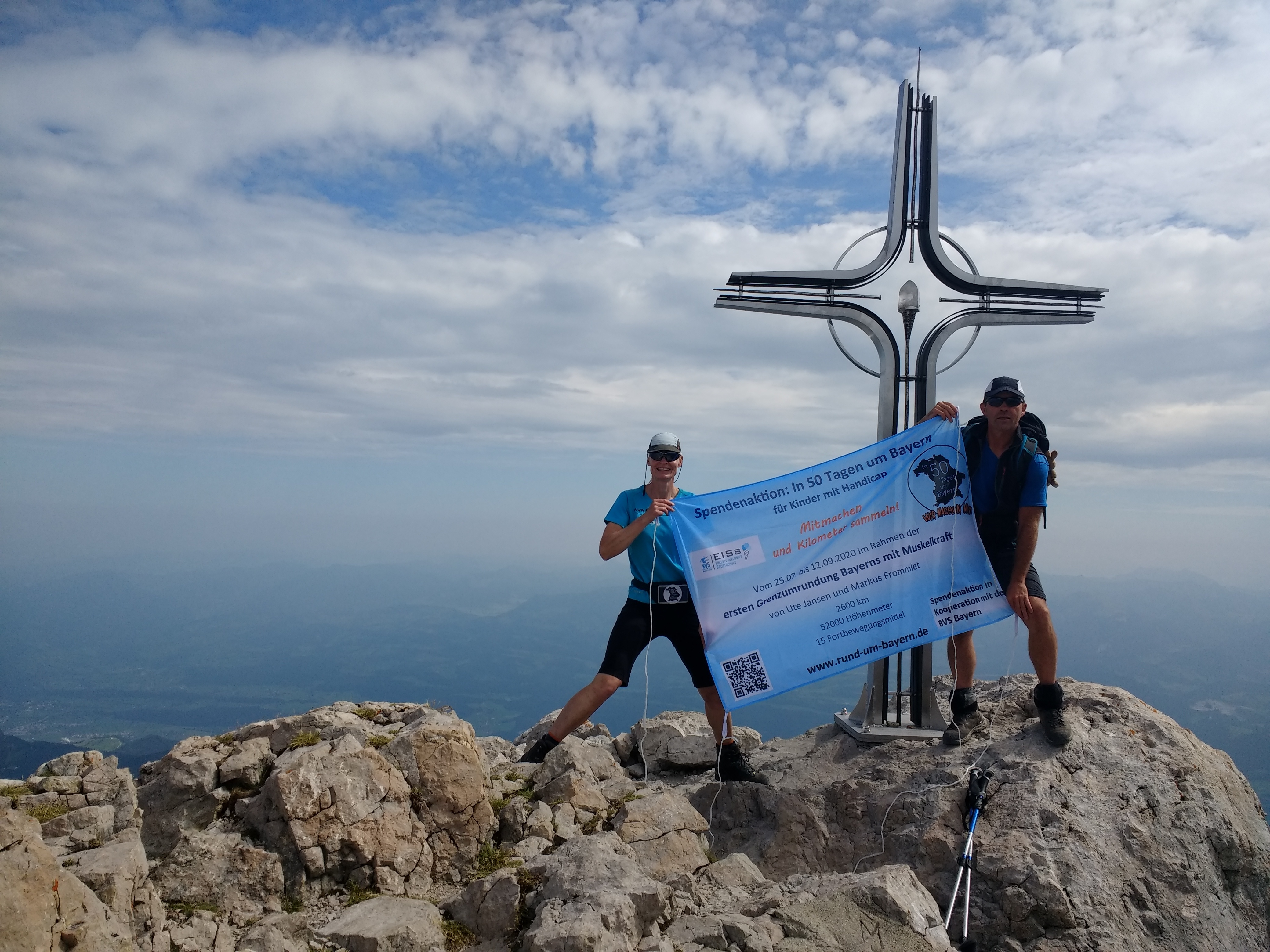 Kleiner Zwischenstop am Gipfelkreuz: Die Döffinger Bayern-Umrunder Ute Jansen und Markus Frommlet bei ihrer Bergtour durch die Berchtesgadener Alpen.