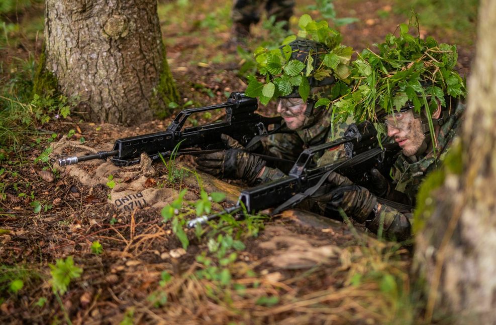 Reservisten halten sich mit Ihren Waffen vom Typ G 36 in einem Graben in Deckung.