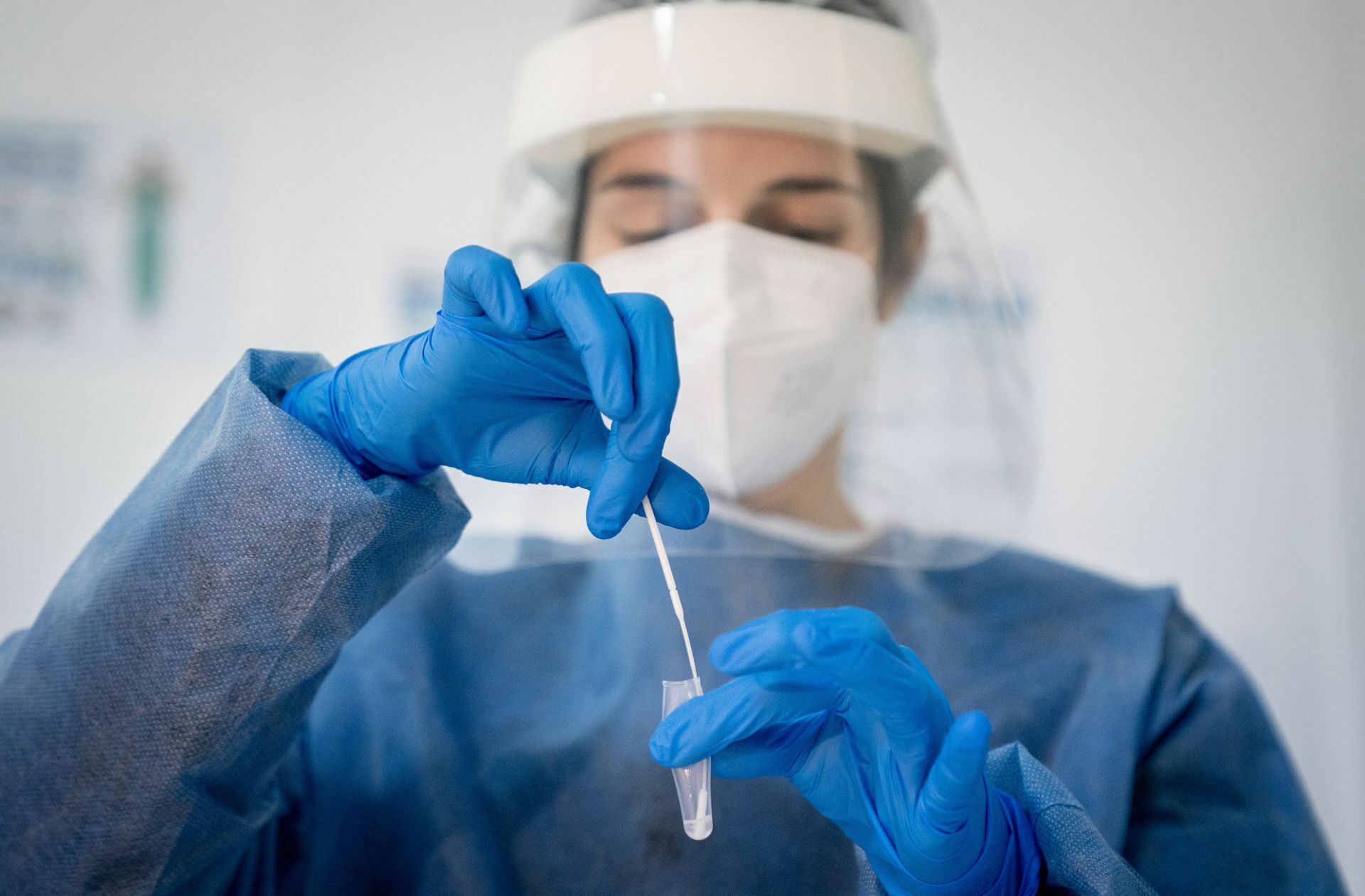 Medizinisch geschultes Personal legt das Wattestäbchen nach dem Abstrich für einen Corona-Schnelltest in eine Lösung. Foto: dpa/Kay Nietfeld