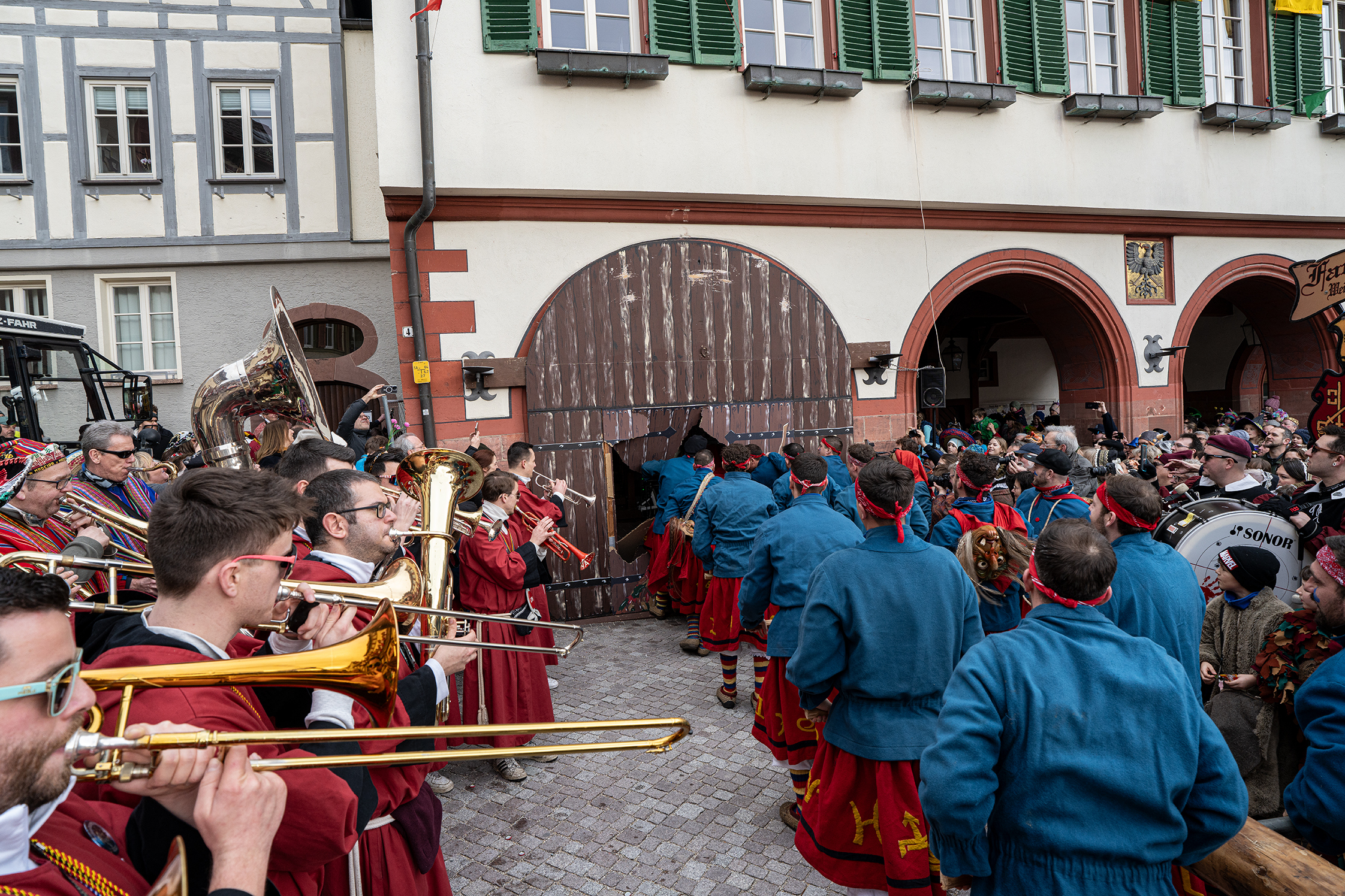 Mit dem Rammbock durchbrechen die Narren in Weil der Stadt das Rathaus-Tor. Bild: Richter