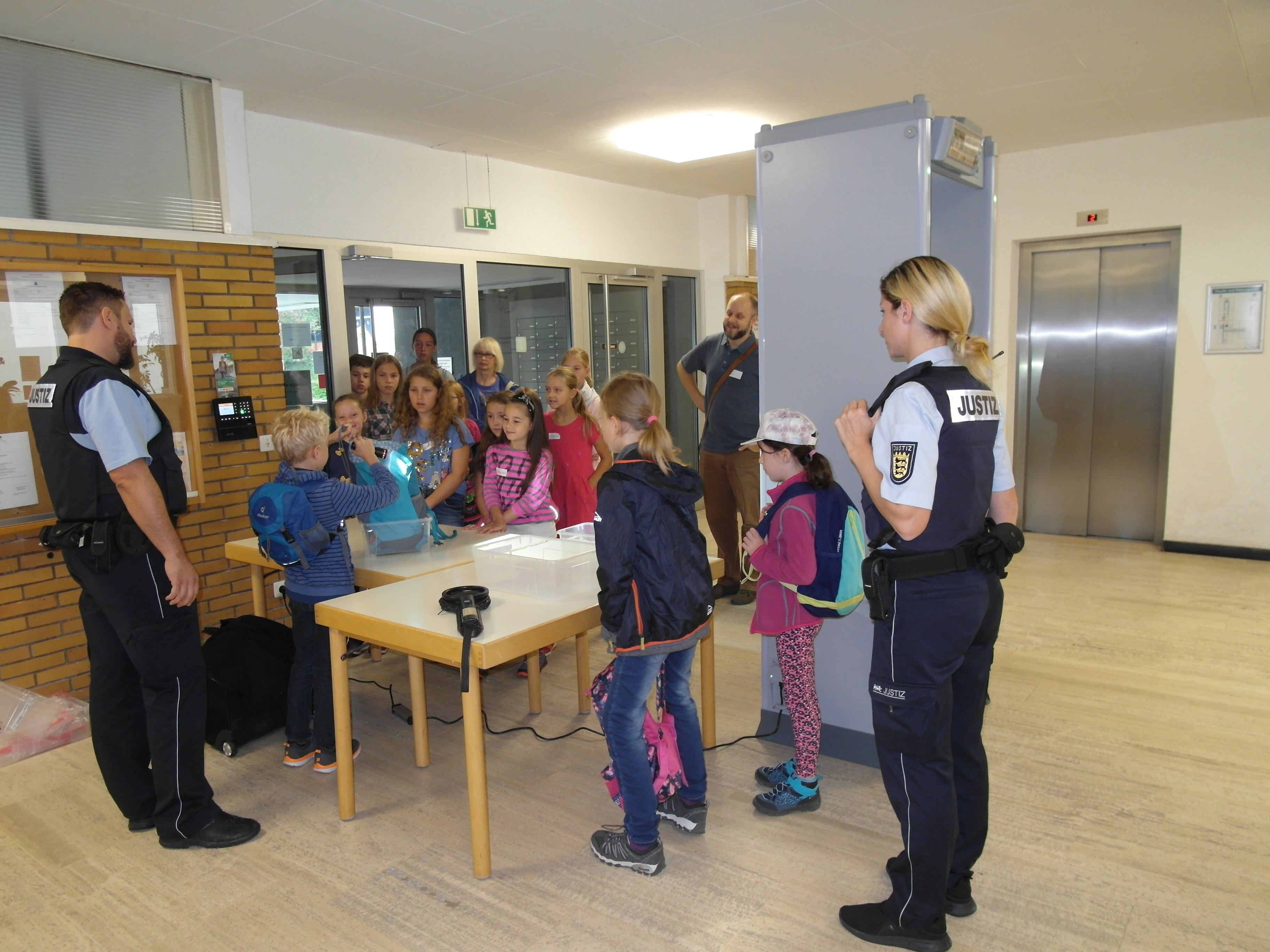 Wie die Taschen am Eingang des Böblinger Amtsgerichts durchsucht werden, dürfen die Kinder im Rahmen des Ferienprogramms des Vereins"Prävent Sozial" unter Anleitung der Wachtmeister Kerstin Horvath und
Senad Ajkuvic selbst ausprobieren. Bild: Staber