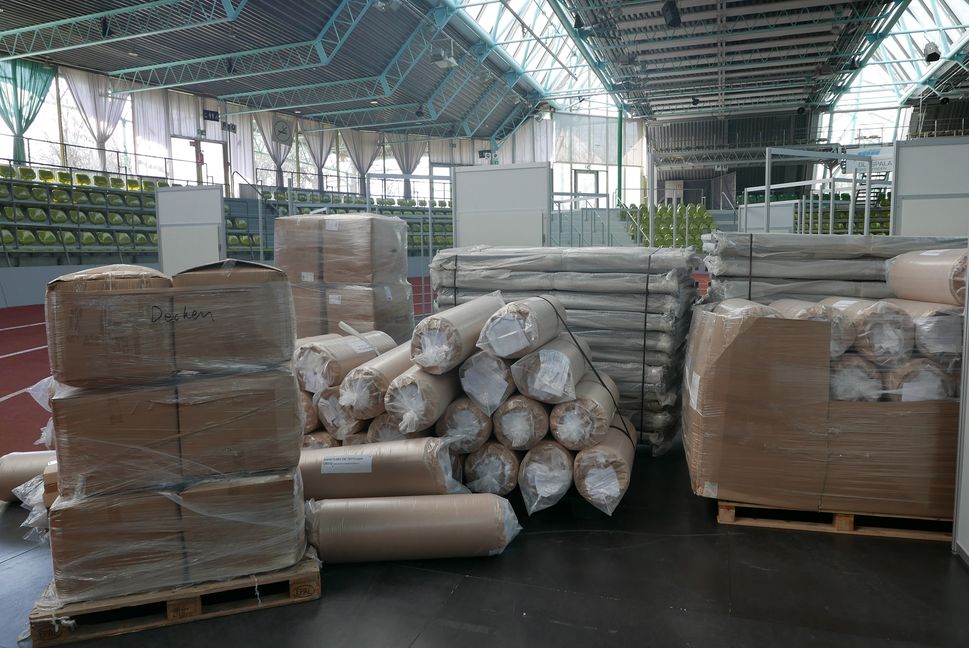 Betten, Matratzen und Decken warten darauf, in die Wohnkabinen eingeräumt zu werden.