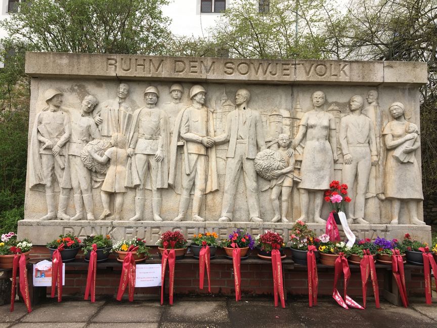 Rote Fahnen von Organisationen wie der DKP Thüringen, Gießen oder der Sozialistischen Deutschen Arbeiterjugend protestieren am Sowjet-Denkmal vor Schloss Hartenfels gegen die NATO.  Bild: P. Bausch