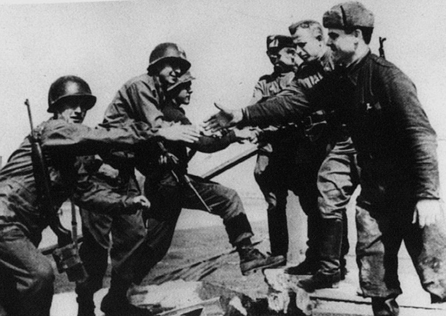 Das historische, aber nachgestellte Foto von der Begegnung amerikanischer und sowjetischer Soldaten auf der zerstörten Elbbrücke im April 1945. Bild: Allan Jackson/z