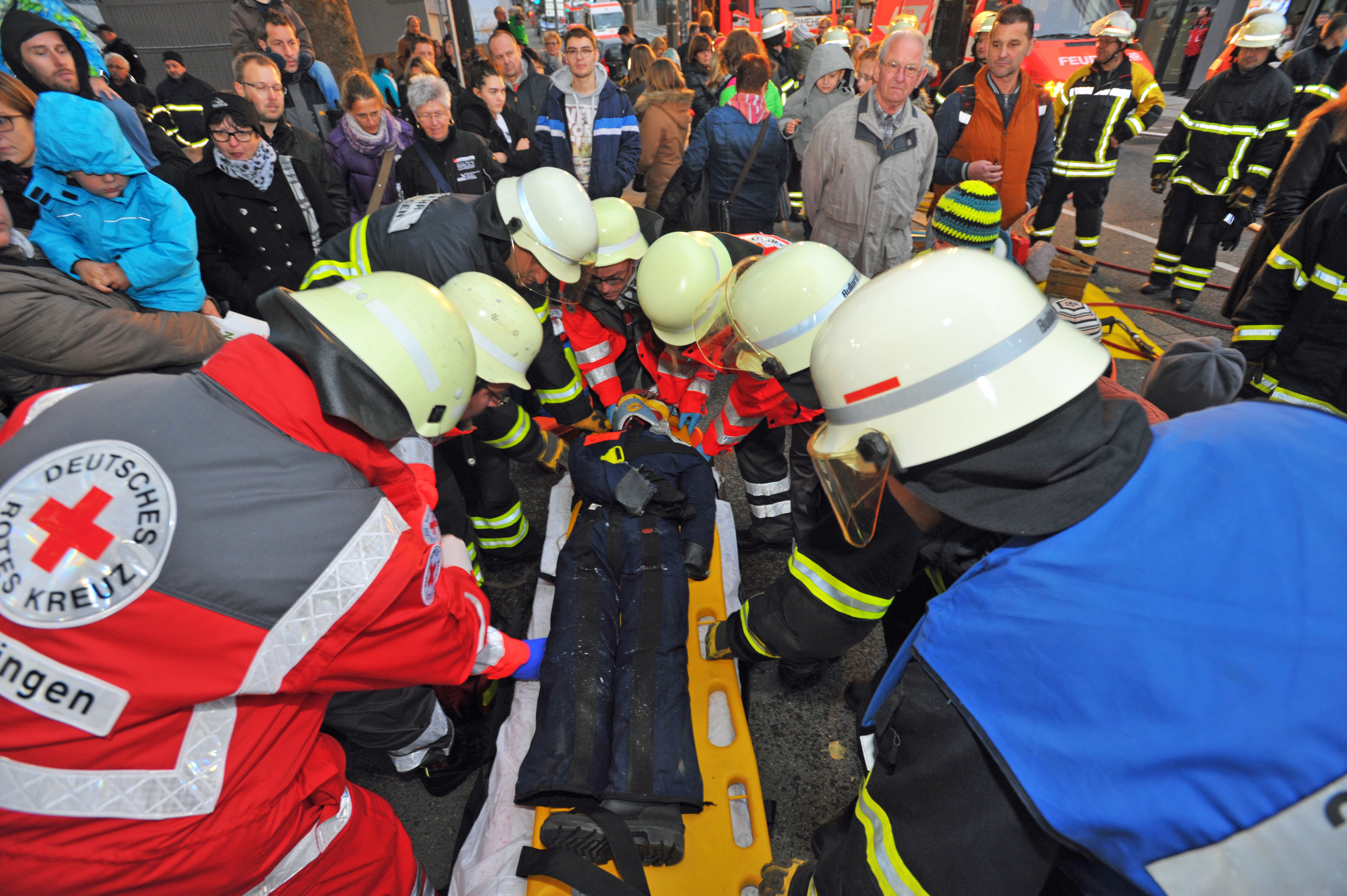 Die Freiwillige Feuerwehr übergibt den aus seinem Auto befreiten Unglücksfahrer an das Rote Kreuz. Bild. Stampe
