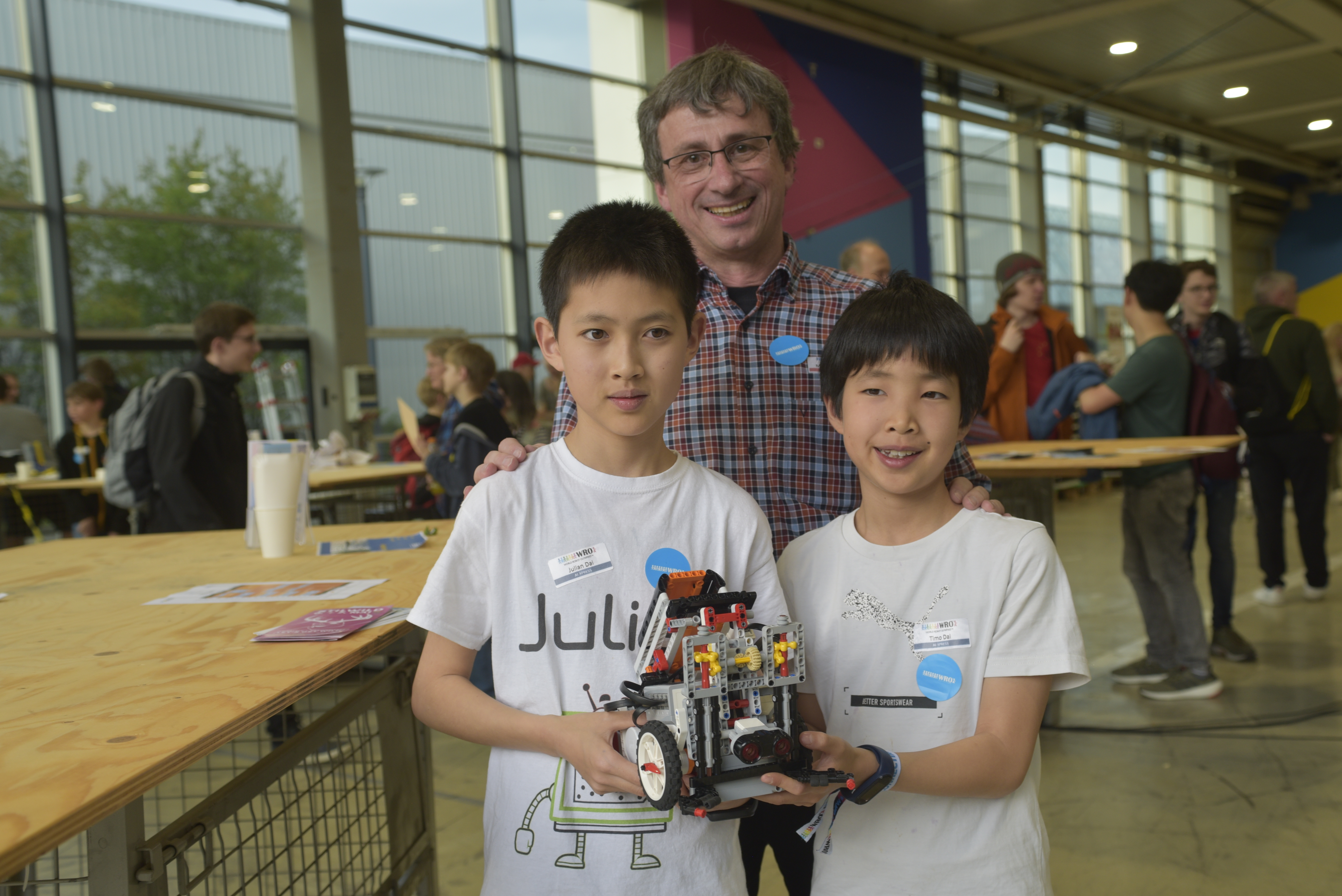 Mit Platz zwei in der Elementary-Klasse qualifizierten sich Julian (links) und Timo Dai mit ihrem Trainer Manfred Gnirss beim Regionalwettbewerb im AI xpress für die Deutsche Roboter-Meistershaft.