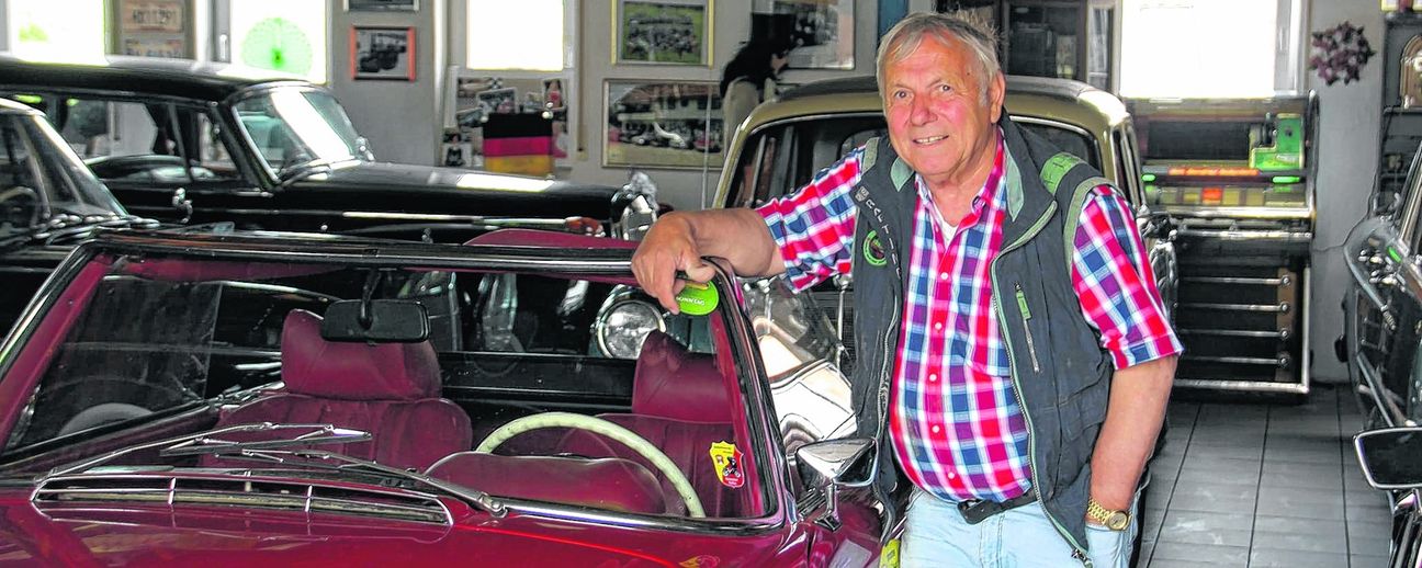 Robert Wanner in seinem Automuseum. Der rote Mercedes 280 SL war sein erster Oldtimer. Es ist stets einsatzbereit.  Bild: Müller