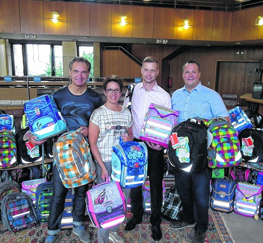 Ralf Maurer, Sandra Maurer, Tobias Heizmann und Alexander Groß (von links) mit den Schulranzen für benachteiligte Kinder.  Bild: Staber