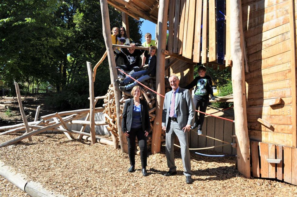 Landrat Roland Bernhard und Schulleiterin Simone Röhm freuen sich, dass die Kinder das neue Klettergerüst gleich in Beschlag genommen haben. Bild: z