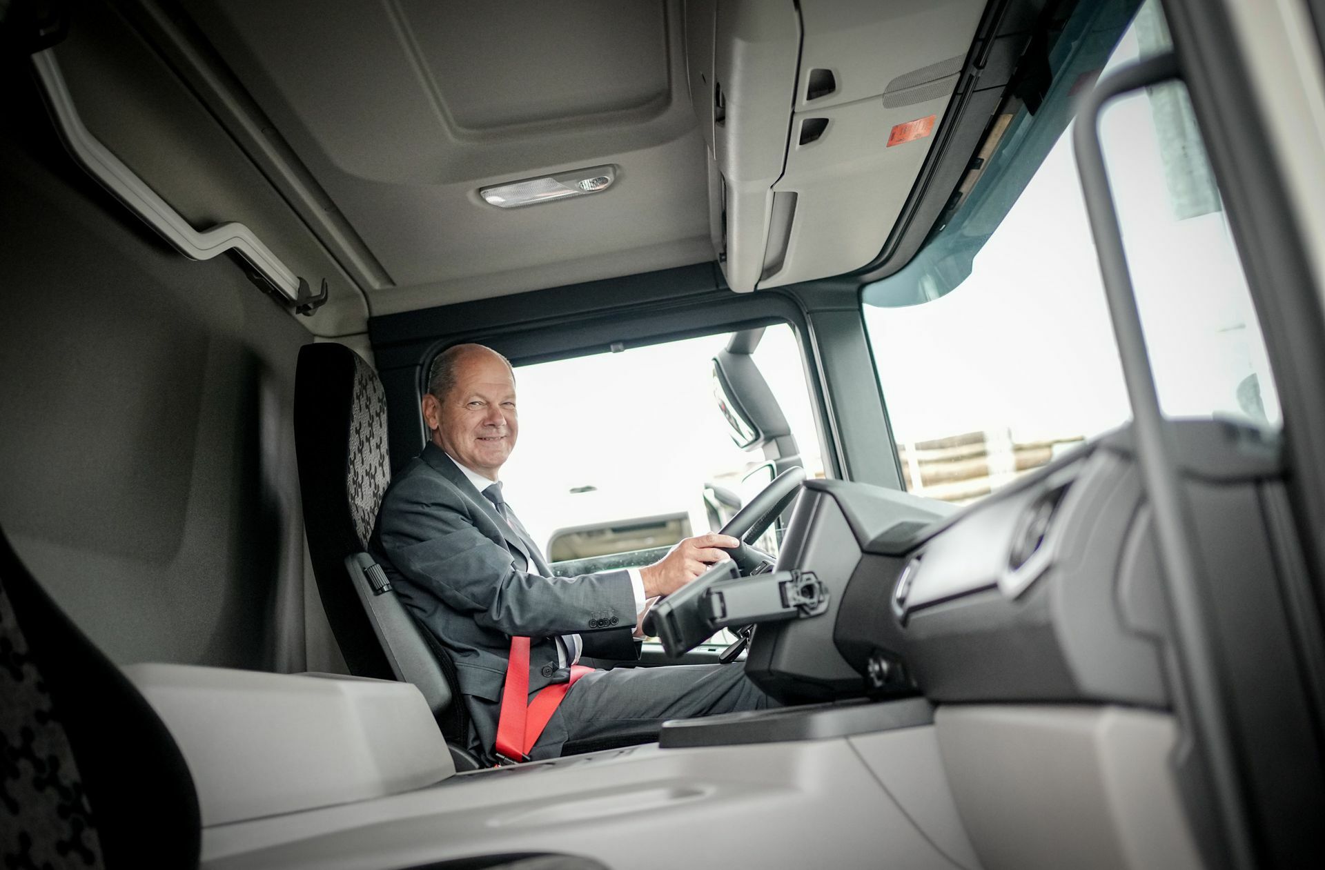 Der Kanzler lenkt bei der Firma Scania einen LKW probeweise.