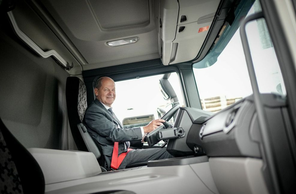 Der Kanzler lenkt bei der Firma Scania einen LKW probeweise.