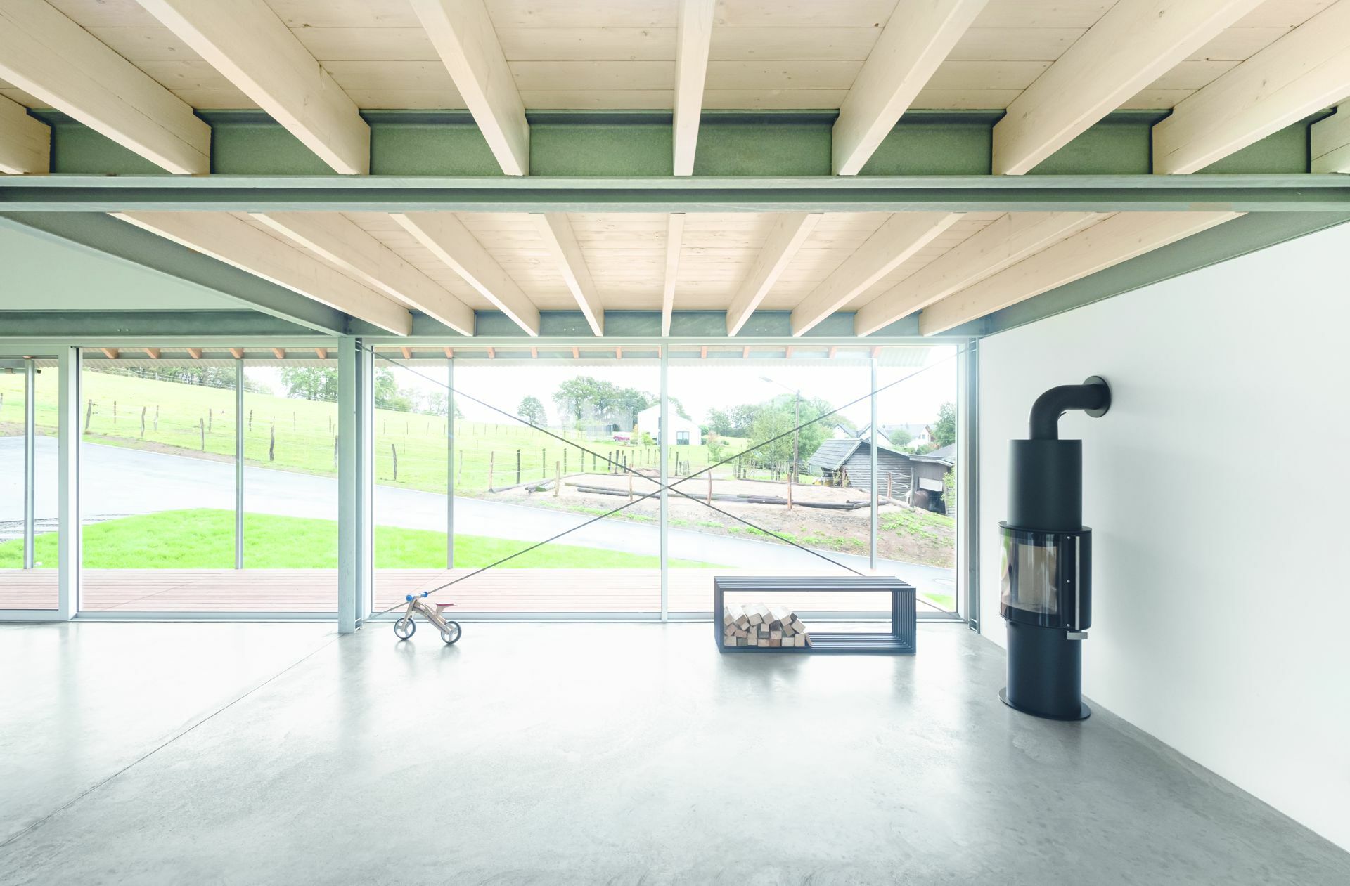 Aretz Dürr Architektur: „Das Langhaus“: Die Auskragung des Giebeldachs richtet sich nach den Sonnenständen. Im Sommer schützt sie den Wohnraum und die längsseitig vorgelagerte Veranda vor Überhitzung. Auch die hinterlüftete Dachhaut aus feinstrukturiertem Wellblech schafft sommerlichen Wärmeschutz, zusammen mit den großformatigen Dachfenstern kühlen die Räume nachts effektiv aus.