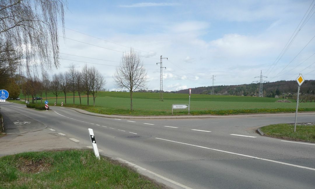 Der Magstadter Ortseingang an der Alten Stuttgarter Straße. Ein Kreisverkehr an der jetzigen Zufahrt zum Sportgelände und auf dem Feld hinter dem weißen Zufahrtsschild soll die etwa aus der Bildmitte kommende Osttangente und die Alte Stuttgarter Straße, die verschwenkt wird, verbinden. Die Baumreihe rechts entlang der Alten Stuttgarter Straße soll erhalten bleiben, sagte Christine König (vom Stuttgarter Stadtplanungsbüro Baldauf) im Gemeinderat. Bild: Reichert
