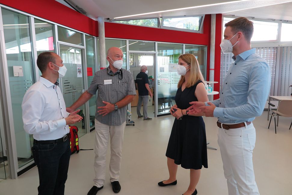 Oberbürgermeister Dr. Stefan Belz, Dr. med. Thomas Leidig (einer der impfenden Ärzte), Wiebke Höfer (Leiterin des Kreisimpfzentrums Sindelfingen) und Erster Bürgermeister Tobias Heizmann im Gespräch vor dem Start des ersten Impftages im Stadtteiltreff Grund. Bild: z