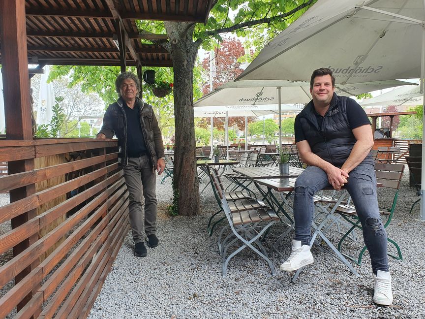„Pille Walter“ Walter Schmidt (links) und Bootshaus-Wirt Tobias Faude sind glücklich, dass der Lockdown endlich vorbei ist. Beide haben am Ufer des Oberen Sees ein gemeinsames Biergarten-Projekt gestartet – und sind gespannt darauf, wie es sich entwickelt. Bild: Wegner