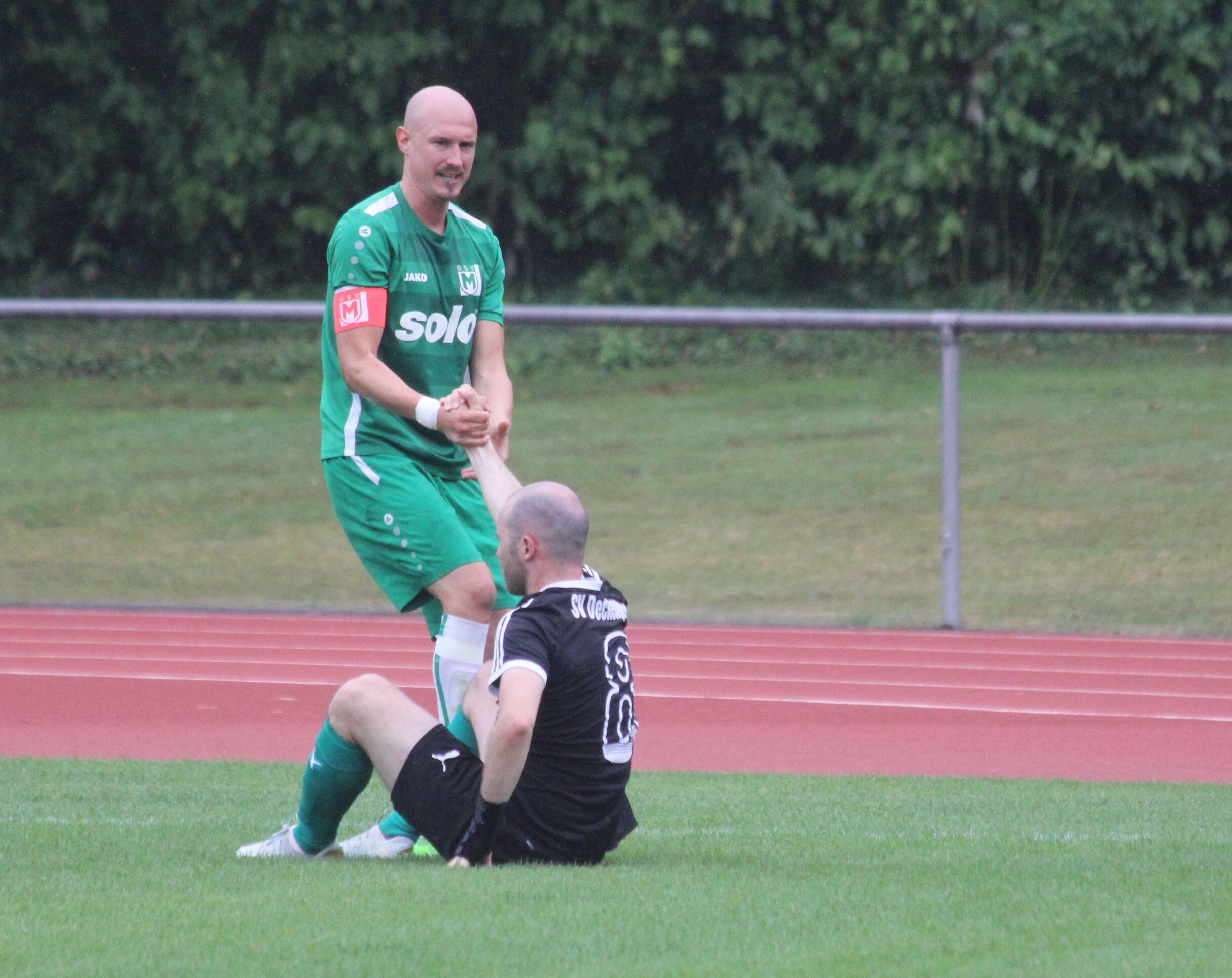 Oliver Klauß hilft Matthias Bäulere (SV Deckenpfronn) auf die Beine. Bild: Oberdorfer