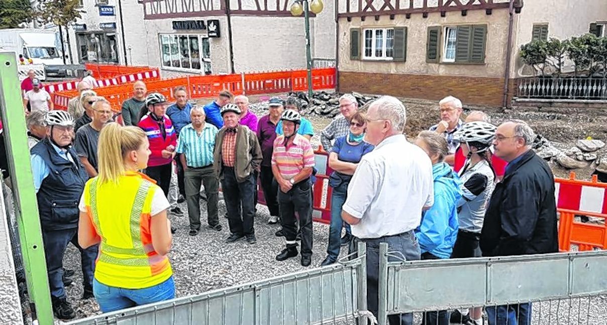 Annette Reinauer (gelbe Weste) und Bürgermeister Wolfgang Faißt erklären den Renningern die Tiefbaustelle in der Malmsheimer Straße.  Bild: z