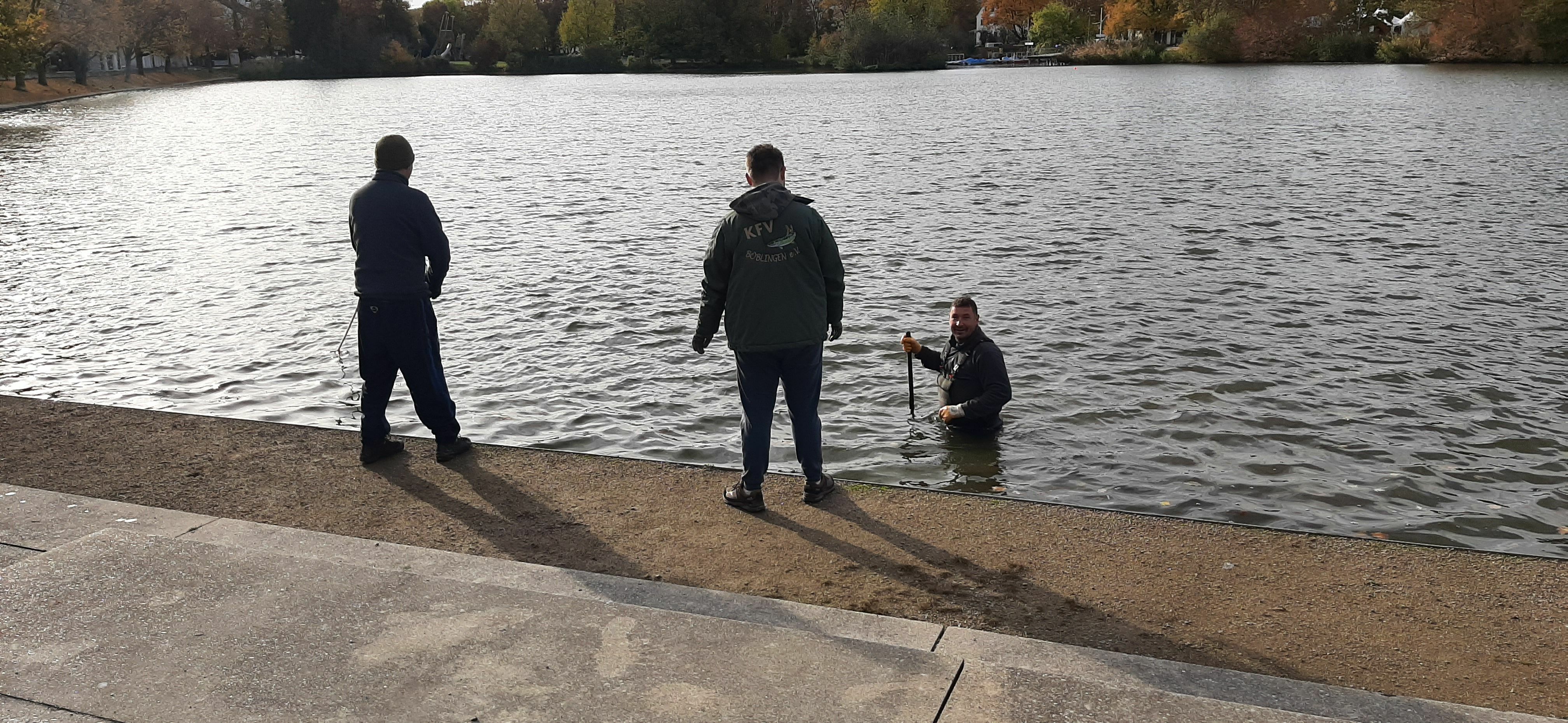 Sebastian Trenkler steht bis über Hüfte im Wasser und kontrolliert den Grund. Bild: Elbers