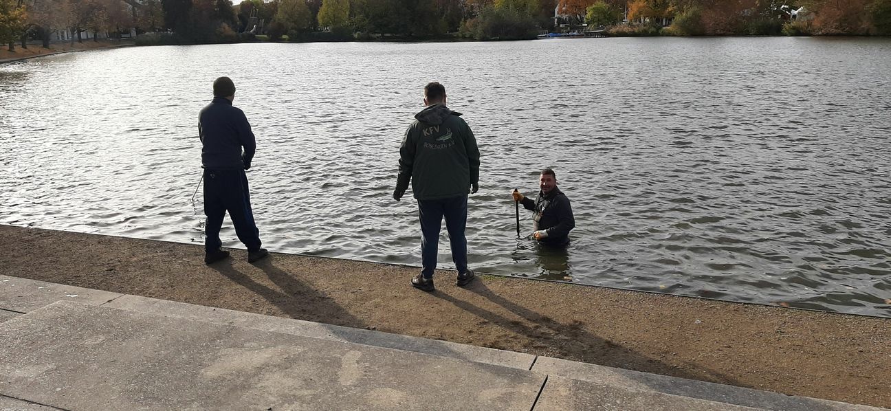 Sebastian Trenkler steht bis über Hüfte im Wasser und kontrolliert den Grund. Bild: Elbers