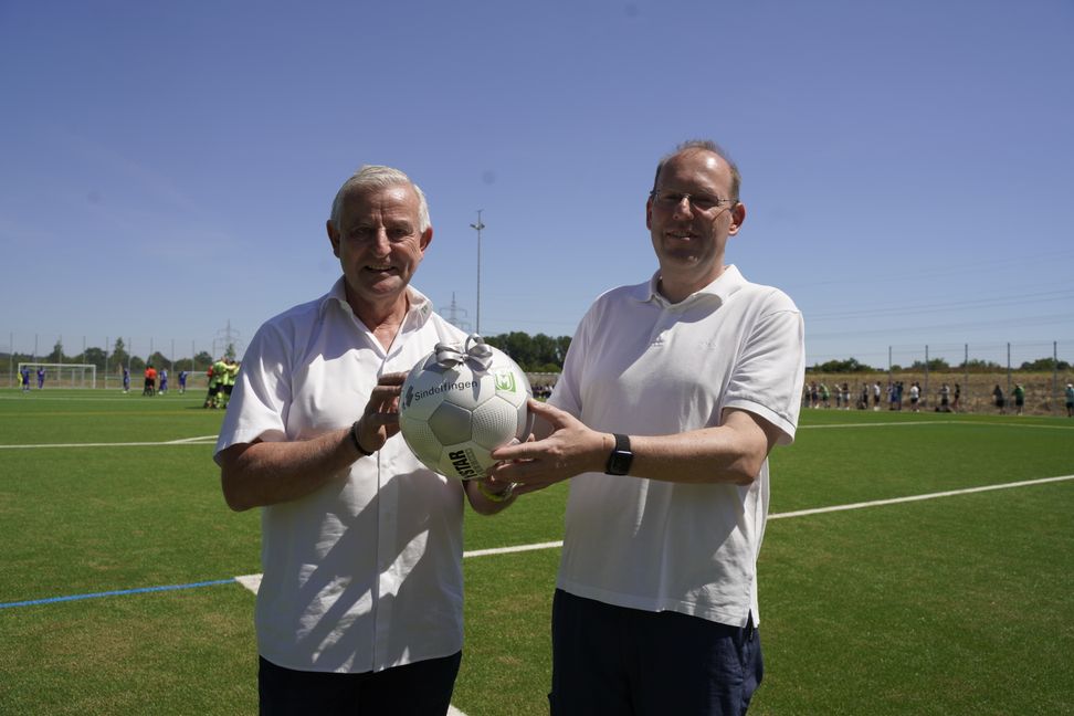 Sindelfingens Oberbürgermeister Dr. Bernd Vöhringer überreicht Maichingens Fußball-Chef Werner Klauß einen Ball zur Eröffnung des Kunstrasenplatzes. Bild: Dettenmeyer