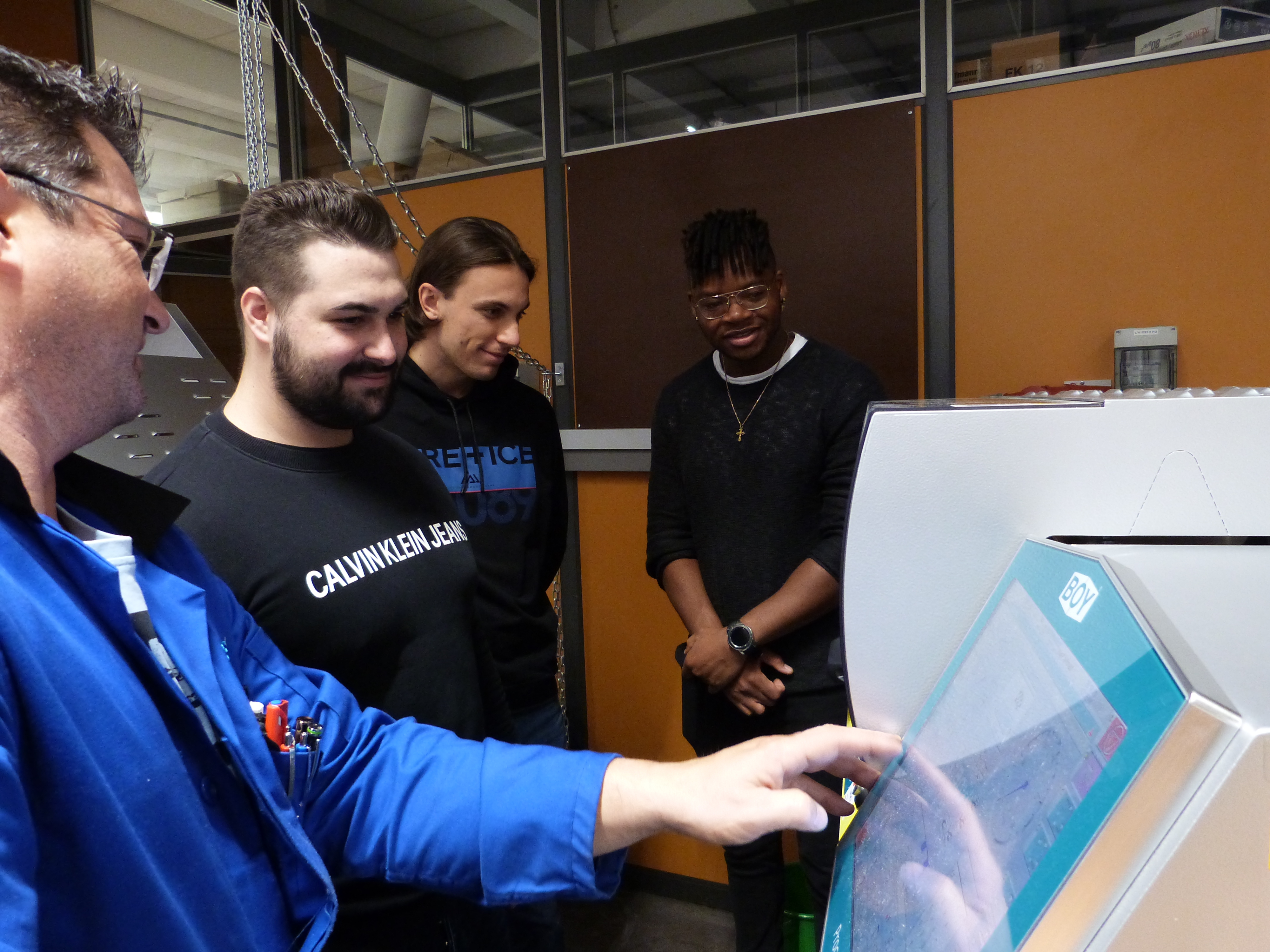 Nils Dolleschell, Dominik Dazend und Rodrigue Adamah arbeiten an den Spritzgussmaschinen  Bild: z