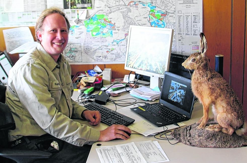 Achim Klausner an seinem Schreibtisch im Büro. Im Sommer ist der Förster oft hier anzutreffen. In den drei anderen Jahreszeiten ist er öfter im Wald.  Bild: Frank Müller