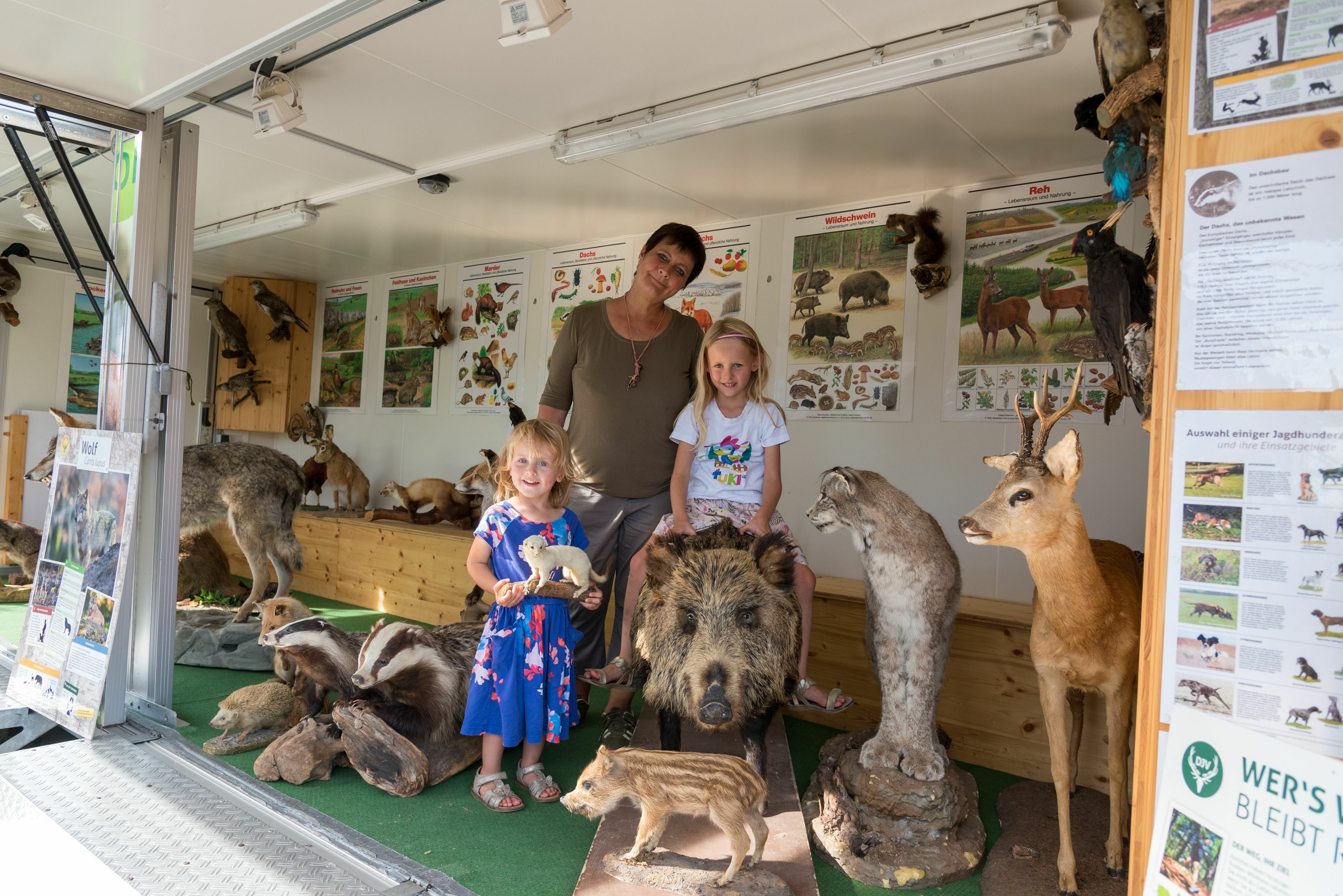 Einmal auf einer Sau reiten, Theresia Rührnschopf nutzte die Gelegenheit beim Infoanhänger Lernort Natur, während ihre Schwester Antonia sich lieber an kleine Tiere hielt. Andrea Gerisch erläuterte den interessierten Kindern die Wildtiere.