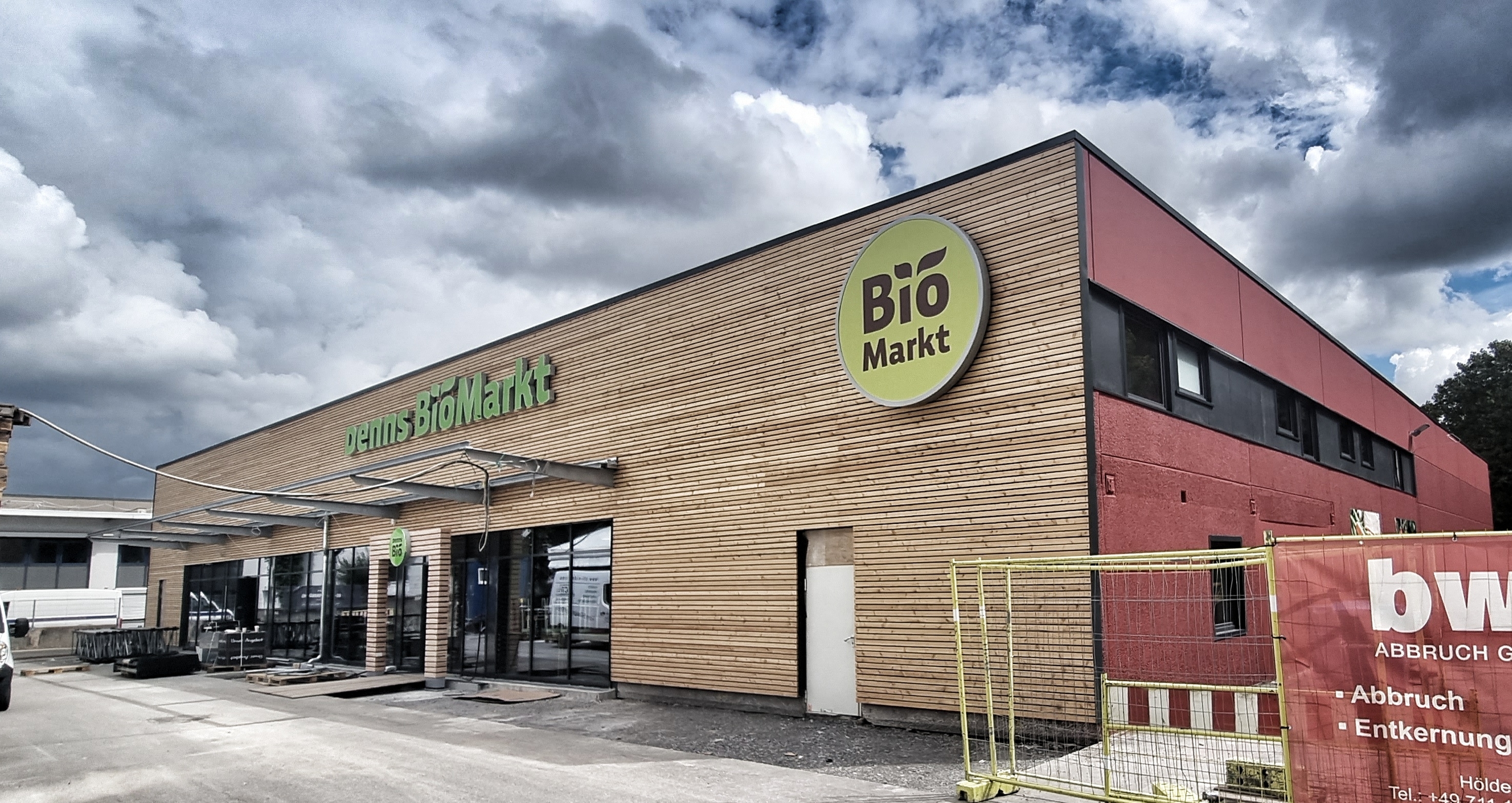 Der Eingang im Röhrer Weg 15 befindet sich künftig an neuer Stelle an einer mit Holz verkleideten Frontseite: Am 24. August will der Biomarkt Denns in dem Gebäude, in dem in den vergangenen 40 Jahren Getränke verkauft wurden, mit einer großen Auswahl an Bio-Angeboten eröffnen.    Bild: Hamann