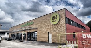 Der Eingang im Röhrer Weg 15 befindet sich künftig an neuer Stelle an einer mit Holz verkleideten Frontseite: Am 24. August will der Biomarkt Denns in dem Gebäude, in dem in den vergangenen 40 Jahren Getränke verkauft wurden, mit einer großen Auswahl an Bio-Angeboten eröffnen.    Bild: Hamann