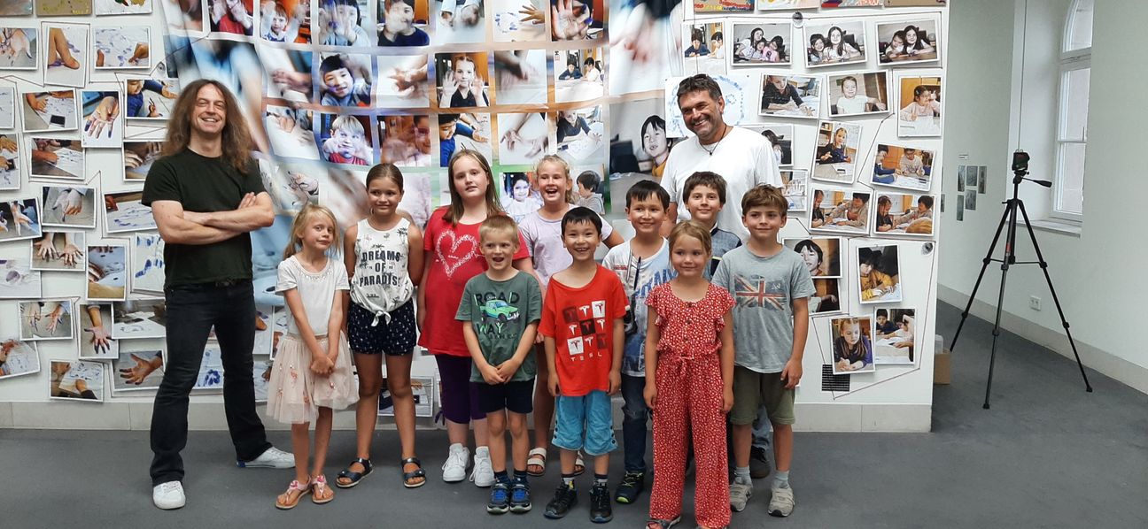 Mathias Mössinger und Karel Limbursky von der Kita Brunnwiesenstraße mit kleinen Künstlern in der Stadtgalerie. Bild: Elbers