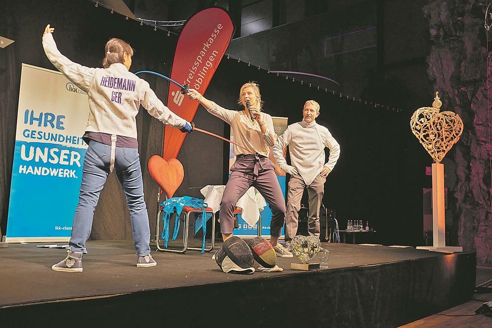 Olympiasiegerin Britta Heidemann (Mitte) moderiert das Einlage-Gefecht zwischen Böblingens Tischtennis-Ass Qianghong Gotsch und V8 Hotel-Chef Simeon Schad. Bild: Kittelberger