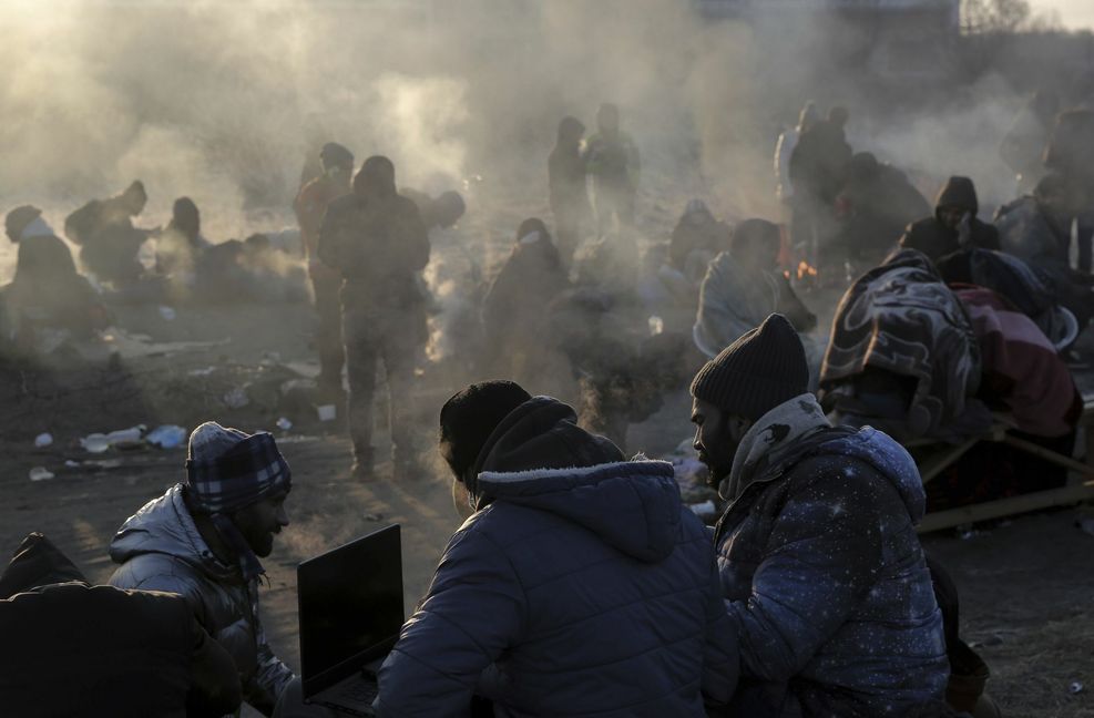 Flüchtlinge, die vor dem russischen Angriff auf die Ukraine geflohen sind, versuchen sich am Grenzübergang Medyka warmzuhalten.