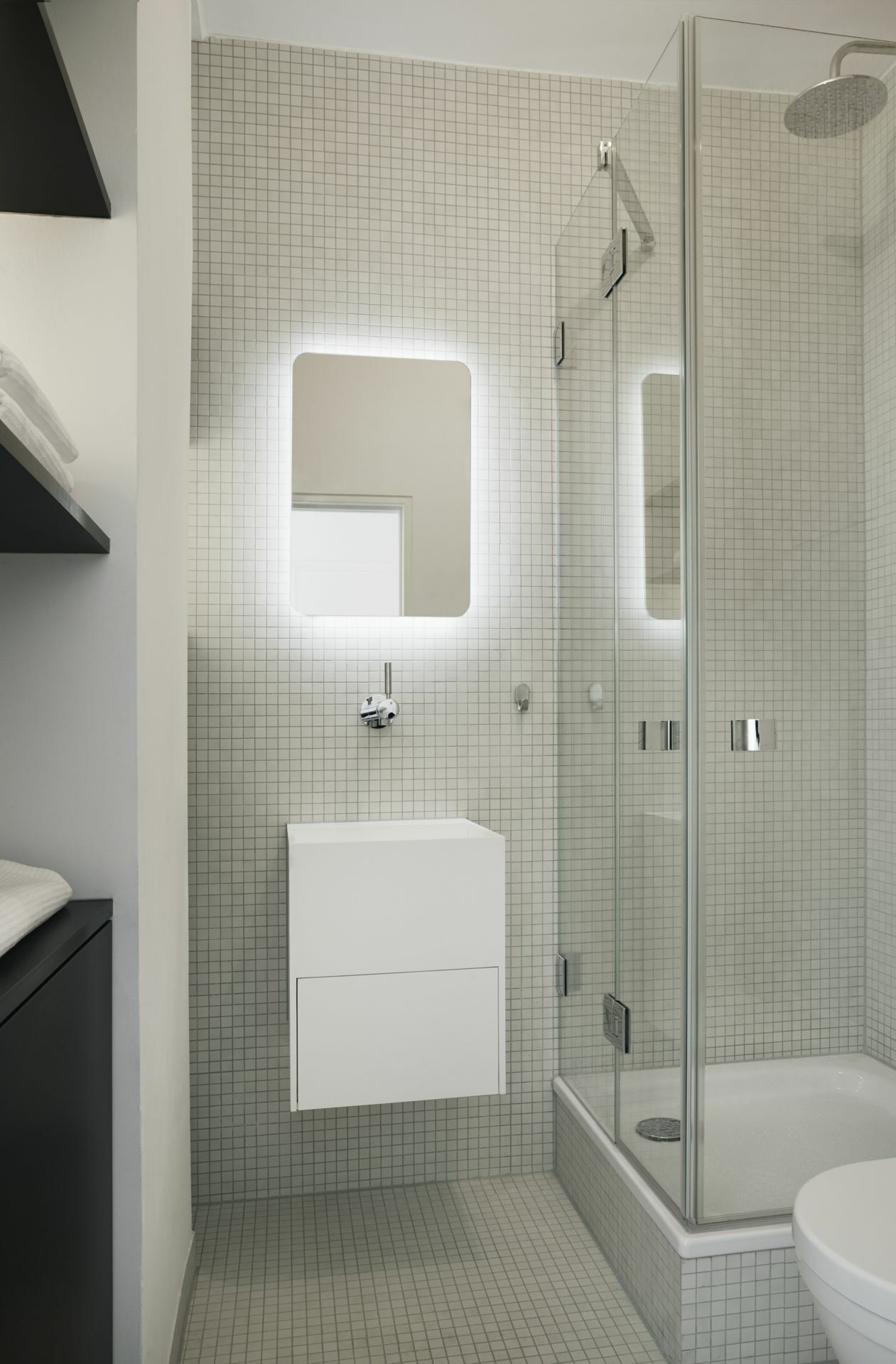 Und so sieht es auch im Badezimmer aus. Wichtig ist, dass es mindestens ein interessantes Element gibt – hier der von hinten beleuchtete Spiegel und die reduzierten Armaturen.