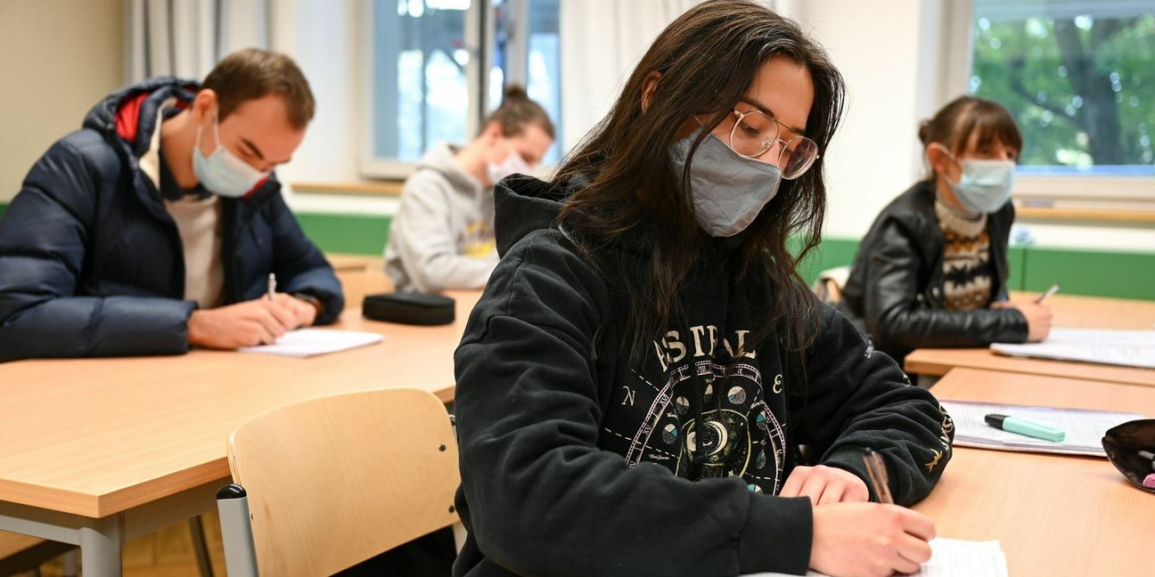 Schüler des Spohn-Gymnasiums in Ravensburg sitzen bei geöffnetem Fenster mit Mund- und Nasenschutz im Unterricht.