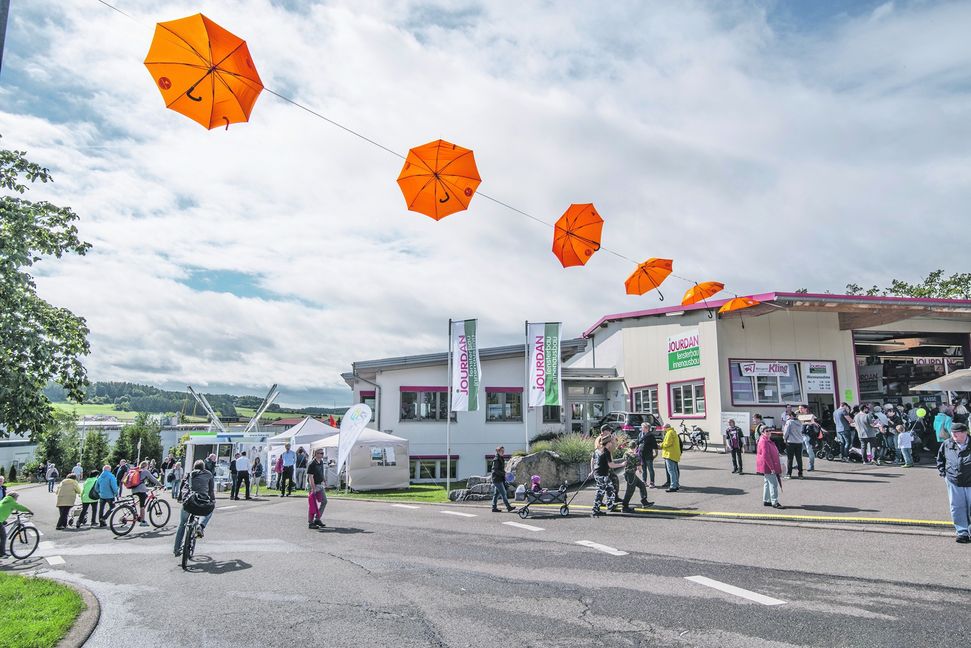 Die orangefarbenen Rettungsschirme über einer Straße bei der Gewerbeschau in Althengstett sollen den Einzelhandel vor dem Onlinehandel retten. Bild: Richter