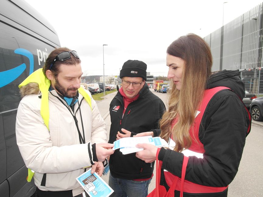 Die Regionalleiterin Dragana Bubulj des Beratungsnetzwerks „Faire Mobilität Südwest“ (rechts) und der baden-württembergische DGB-Vorsitzende Kai Burmeister (Mitte) im Gespräch mit einem Paketzusteller aus Albanien. Bild: Staber