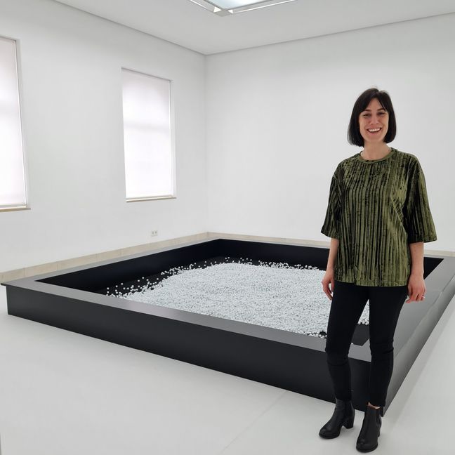 Hannah Eckstein vor der interaktiven Installation "Digitales Schlaraffenland - eine Ode an die Binärarchitektur" von Olsen mit über 50.000 modifizierten Würfeln mit nur 0 und 1. Bild: Schilpp