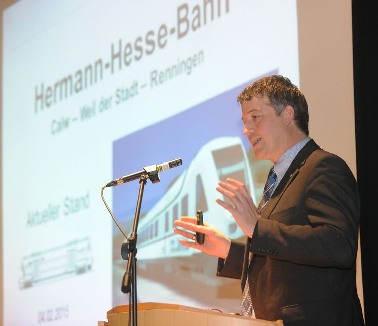 Michael Stierle, im Calwer Landratsamt zuständig für den Öffentlichen Personen-Nahverkehr, erläuterte in der voll besetzten Althengstetter Festhalle die Planung und Bewertung der Hermann-Hesse-Bahn. Bild: Fritsch