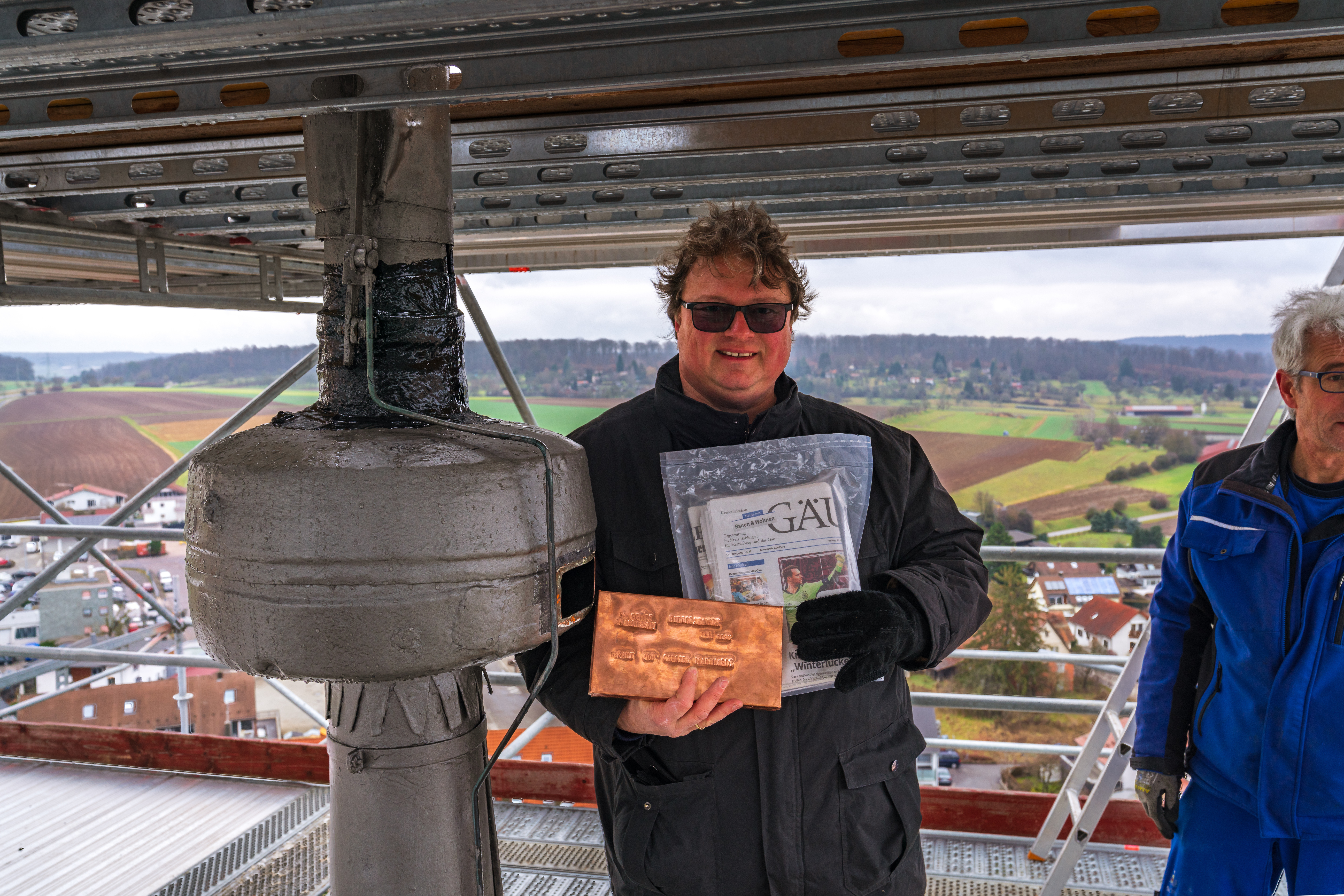Pfarrer Andreas Roß neben dem Turmknauf der Nikomedeskirche. Bild: Gerhard Läpple